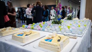 Varia-kakkuja ja kahvikuppeja pöydällä.