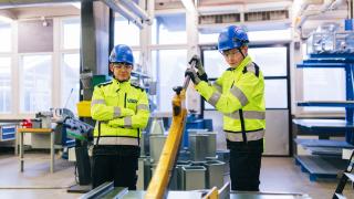 Kaksi talotekniikan opiskelijaa leikkurin kanssa.