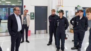 Kaupunginjohtaja ja lentokoneasennuksen opiskelijoita.