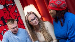 Sosiaali- ja terveysalan kolme opiskelijaa kannettavan tietokoneen äärellä.