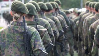 Joukko varusmiehiä selkäpuolelta kuvattuna.