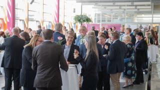 Juhlavasti pukeutuneita ihmisiä juttelee keskenään Varian juhlissa