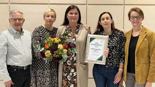 Keijo Mikkonen, Anne Heinonen, Minna Tuomi, Anne Sivonen ja Irene Toivola. Minna Tuomella on käsissään kukkakimppu ja kunniakirja.