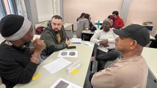 Opiskelijoita pöydän ääressä.