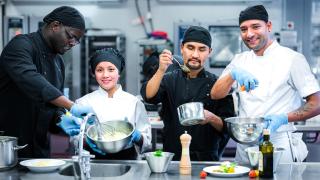 Varian kokkiopiskelijat valmistavat ruokaa opetuskeittiössä.