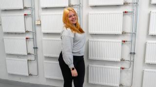 Yolanda seisoo patteriseinän edessä.