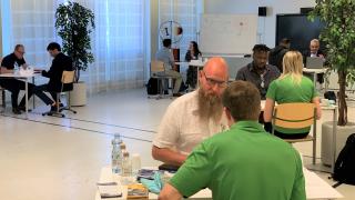 Hakijoita ja työnantajia pöytien äärellä keskustelemassa.