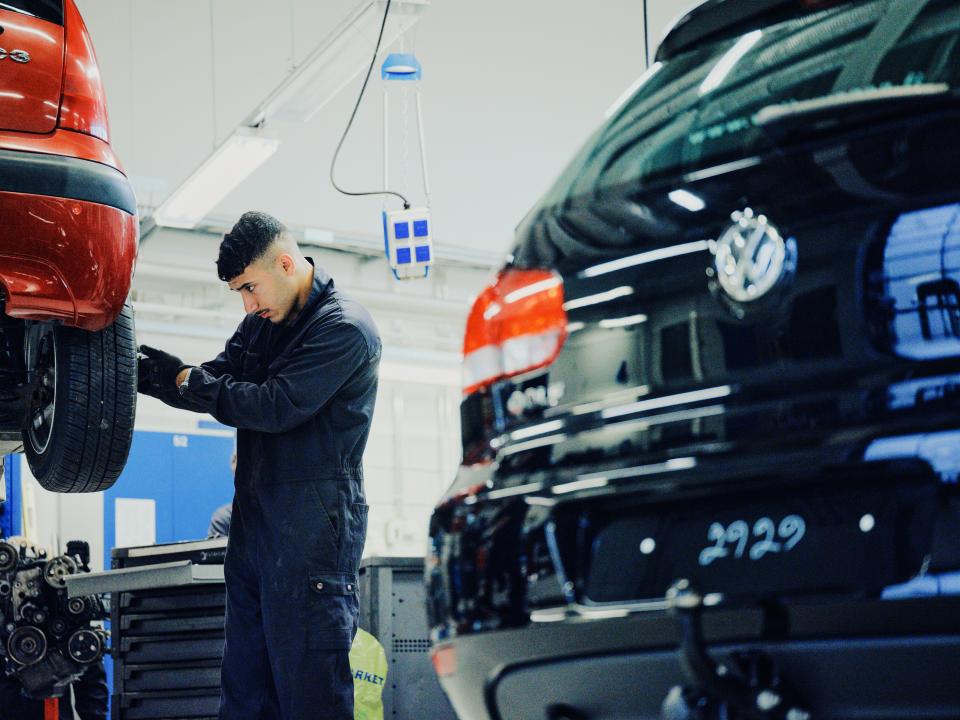 Opiskelija korjaa autoa.