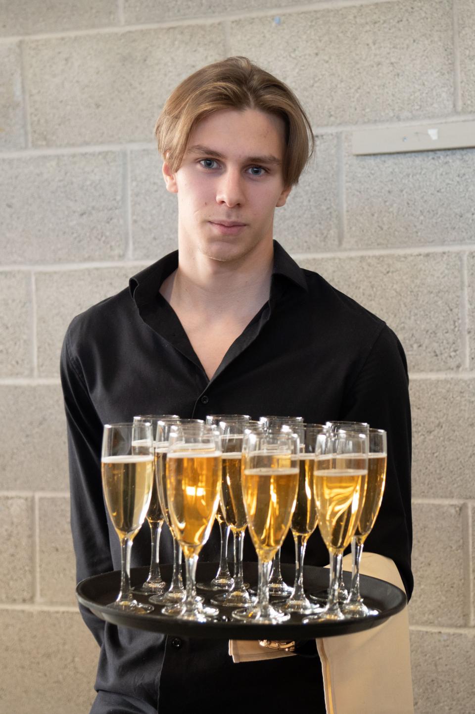 Varian opiskelija tarjoilee tervetuliaisjuomia.