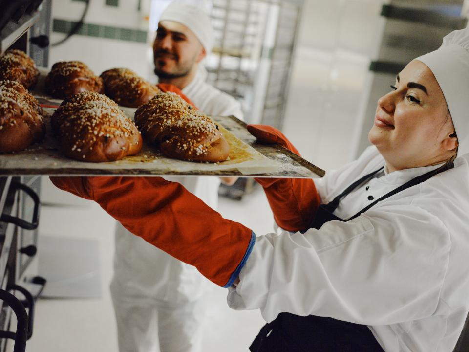 Leipuri ottaa pullia uunista.