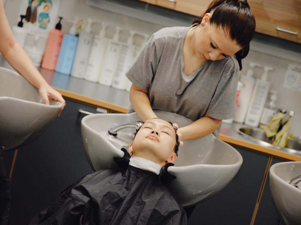 Hiusten pesu koulusalongissa.