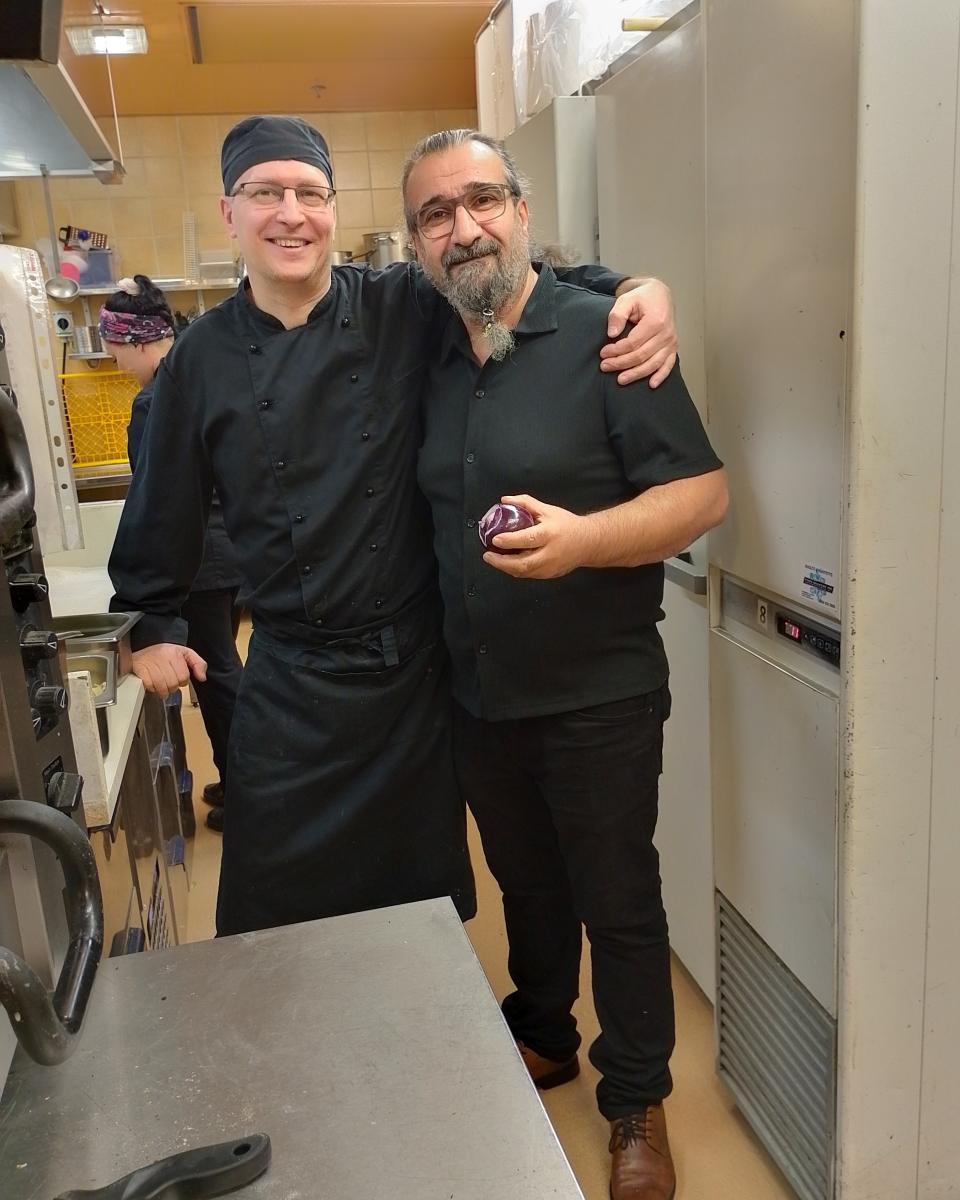 Kaksi henkilöä hymyilee työvaatteissa.